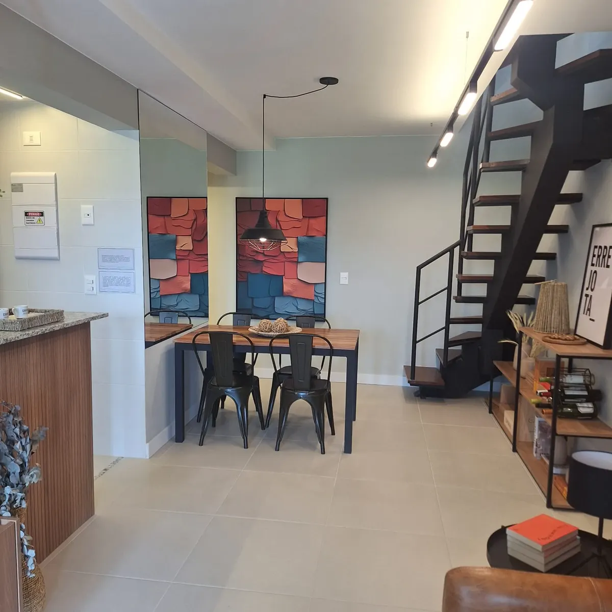 Living da cobertura decorada, com escada para o terraço e mesa de jantar