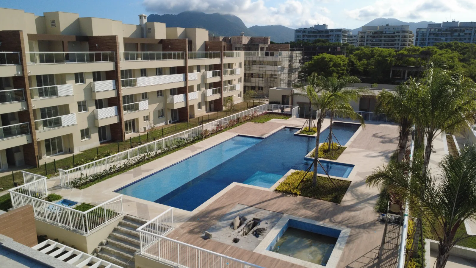 Foto real do clube do Palms pronto, com as piscinas e os prédios