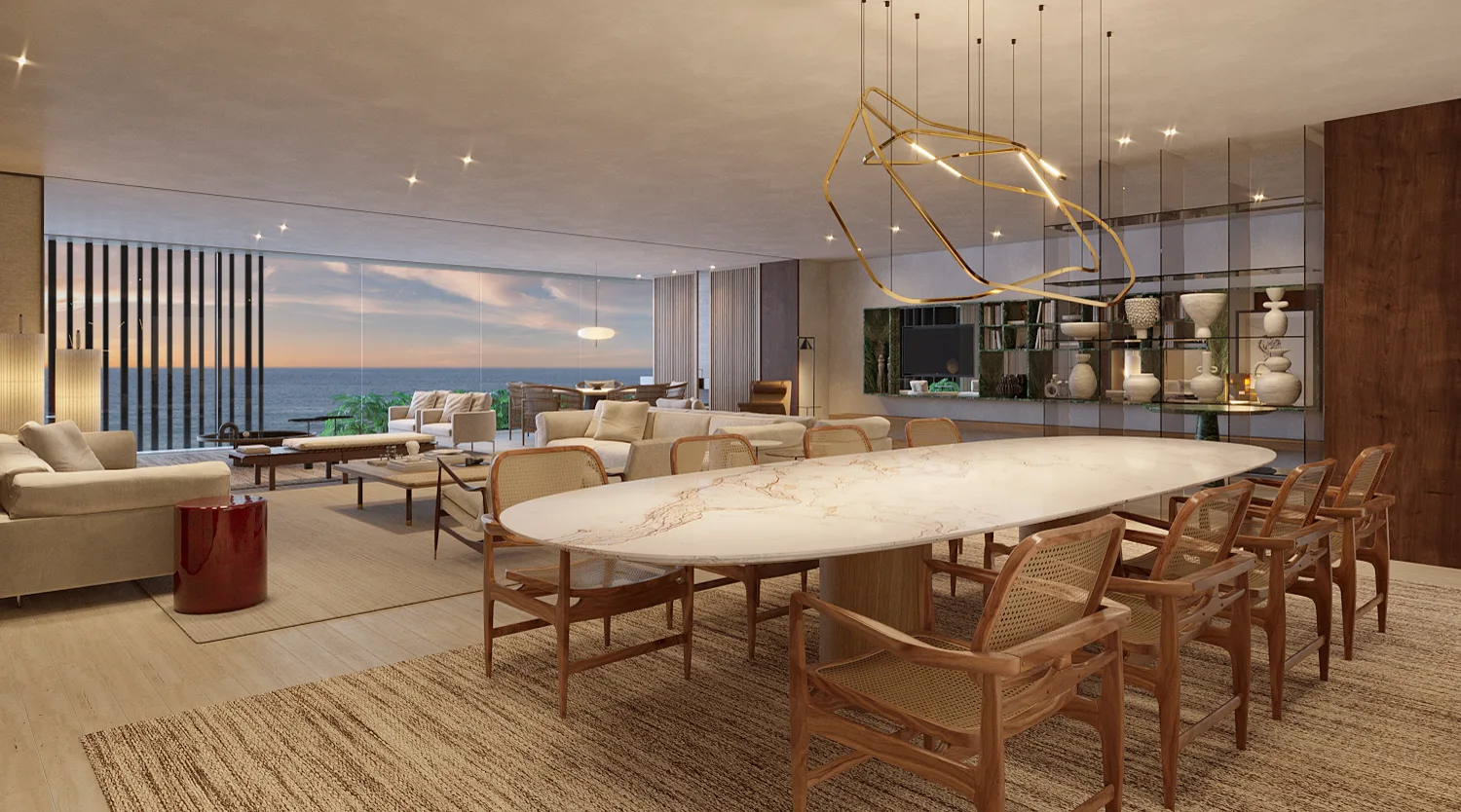 Sala de jantar com mesa de pedra e vista para o mar ao entardecer